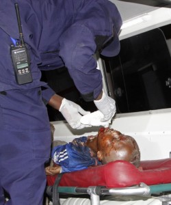 A Somali man helps an injured civilian following a suicide car bomb attack on a hotel in Mogadishu, Somalia, Friday, Feb, 26 2016. A suicide bomber rammed his car into a hotel's entrance in Mogadishu and blew it up, allowing Al-Shabab gunmen to force their way into the hotel, exchanging fire with hotel guards and leaving 14 dead before government security forces ended the attack, including four gunmen and the suicide bomber. (AP Photo/Farah Abdi Warsameh)